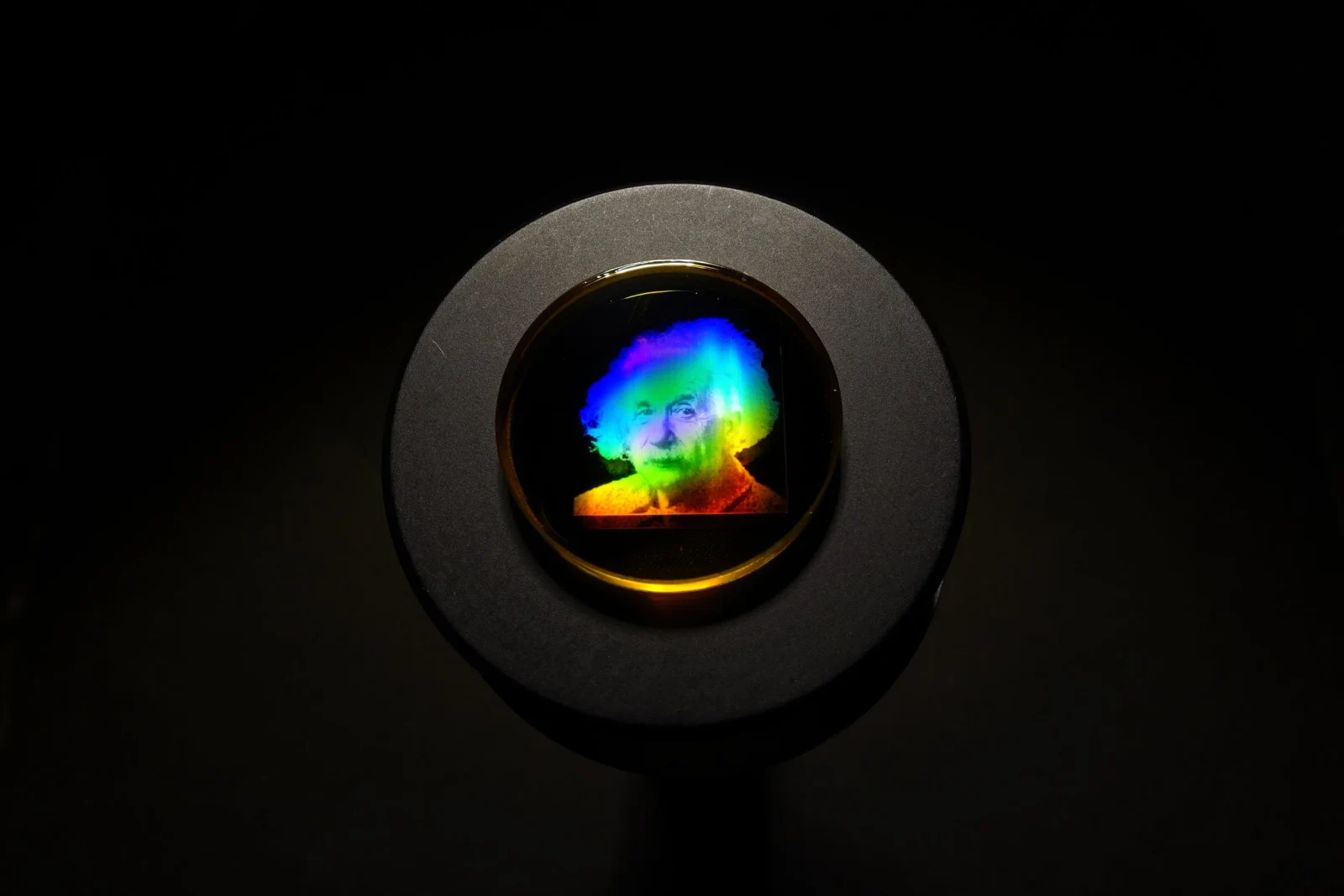 A rainbow-colored portrait of Albert Einstein on a mounted optical sample